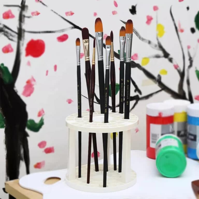 Plastic artist paintbrush holder on desk with paintbrushes